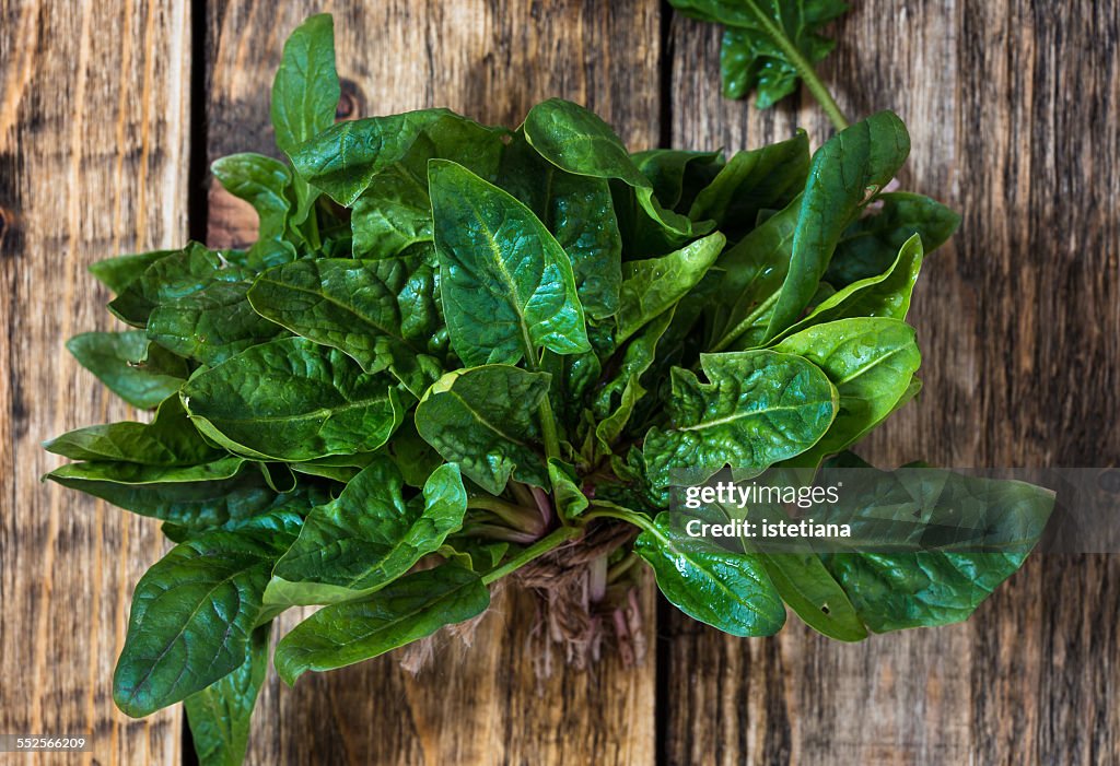 Fresh organic spinach on wooden background