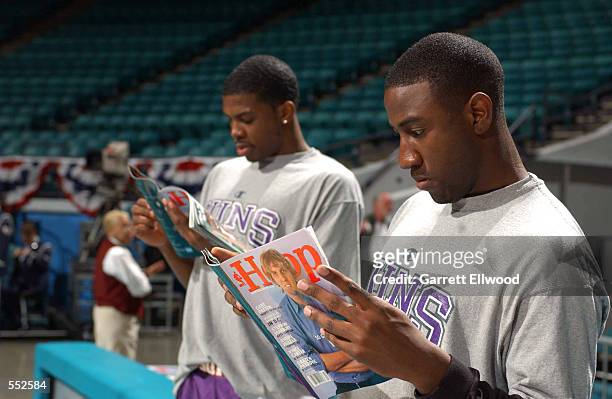 Guards Milt Palacio and Joe Johnson of the Phoenix Suns read the latest edition of Hoop Magazine before the NBA game against the Charlotte Hornets at...