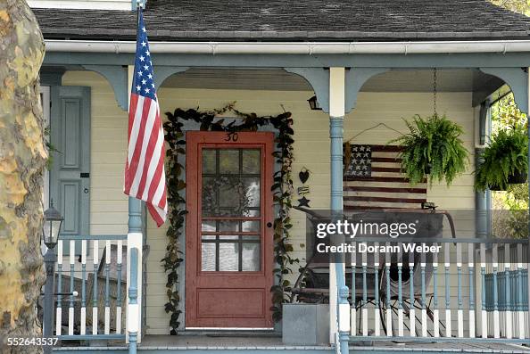 A Victorian style home with a porch, two America flags in Mount... News ...