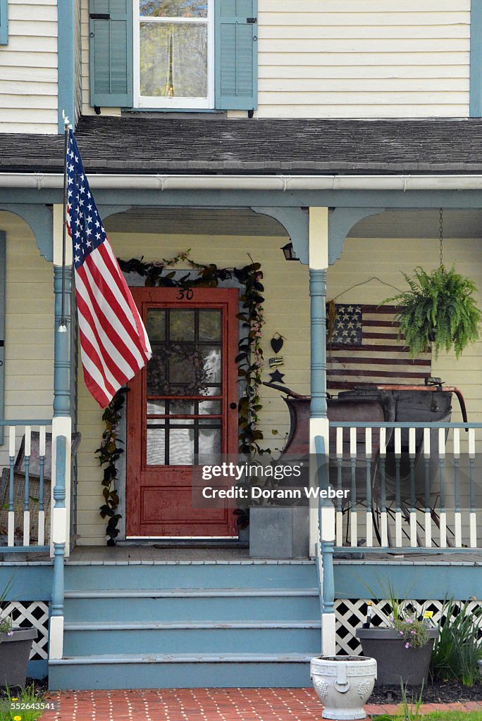 A Victorian style home with a porch, two America flags in Mount... News ...