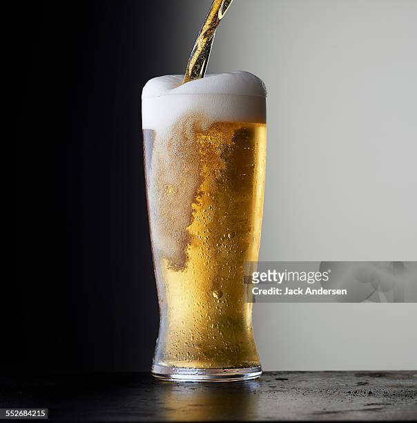 stock beer - overflowing glass stockfoto's en -beelden