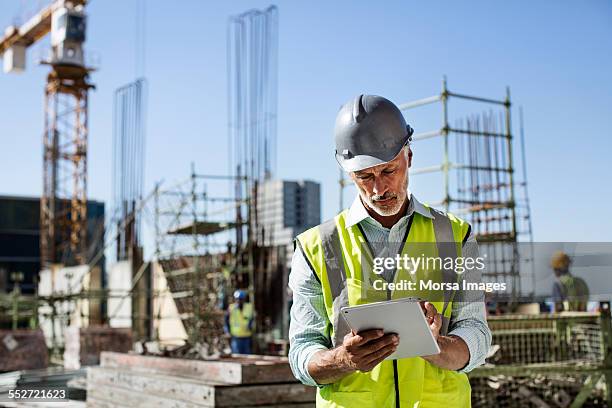architect using digital tablet at site - digital tablet stock pictures, royalty-free photos & images