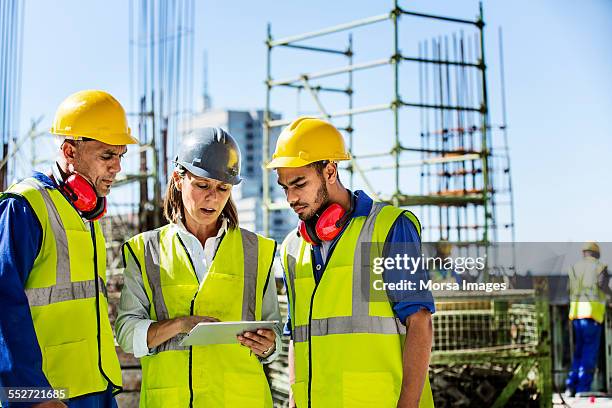 architects using digital tablet at site - construction site tech stockfoto's en -beelden