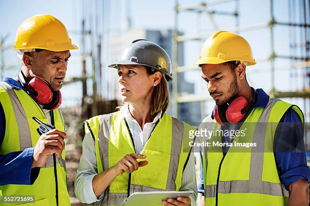 architects using digital tablet at site - helmet worker stock pictures, royalty-free photos & images