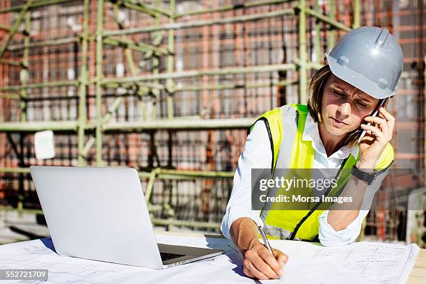 architect using mobile phone while working at site - architect on site fotografías e imágenes de stock