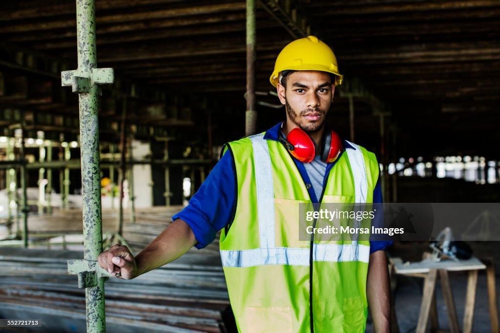 Confident construction worker standing at site