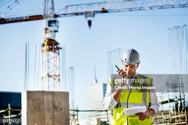 architect using walkie-talkie at construction site - walkie talkie stock pictures, royalty-free photos & images