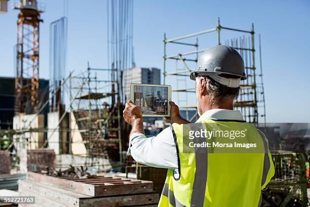 male architect photographing construction site - construction site tech stockfoto's en -beelden