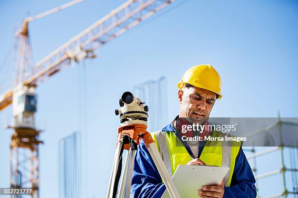 architect writing on clipboard at site - work helmet stock pictures, royalty-free photos & images