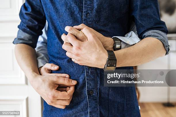 gay couple hugging and holding hands - love connection family stockfoto's en -beelden