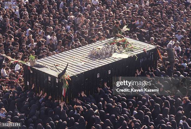 Thousands of people gather around a container holding the body of Ayatollah Khomeini, in his final resting place near Behesht Zahra cemetery in...