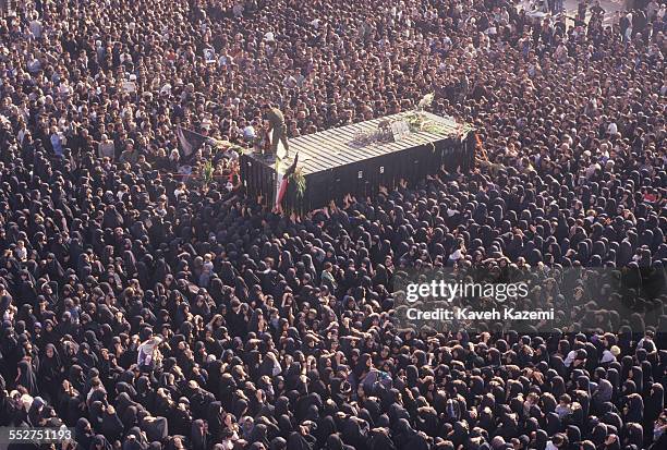 Thousands of people gather around a container holding the body of Ayatollah Khomeini, in his final resting place near Behesht Zahra cemetery in...