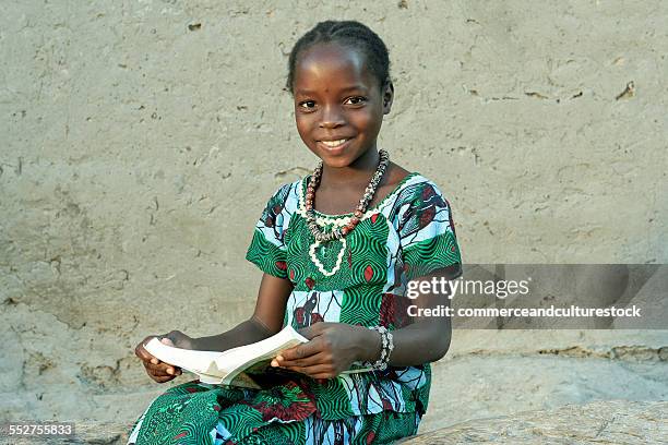 a smiling girl with a book - africa school stock pictures, royalty-free photos & images