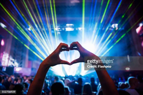 woman making heart shape with hands at music event - bash 2015 concert imagens e fotografias de stock
