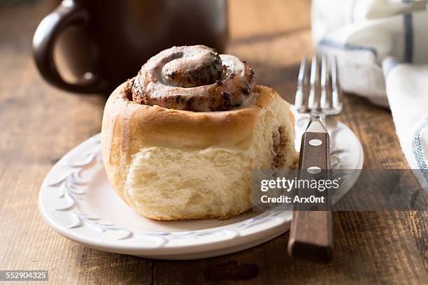 cinnamon bun with cup of coffee, close up - sweet bread fotografías e imágenes de stock