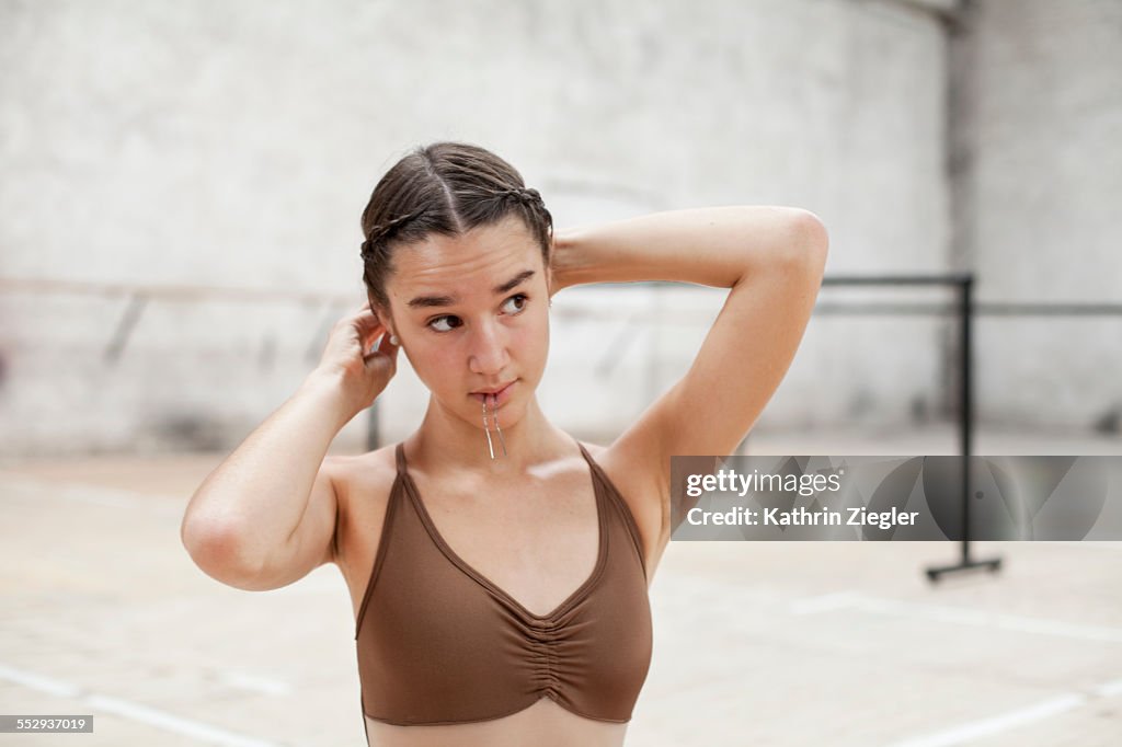 Young ballerina doing her hair