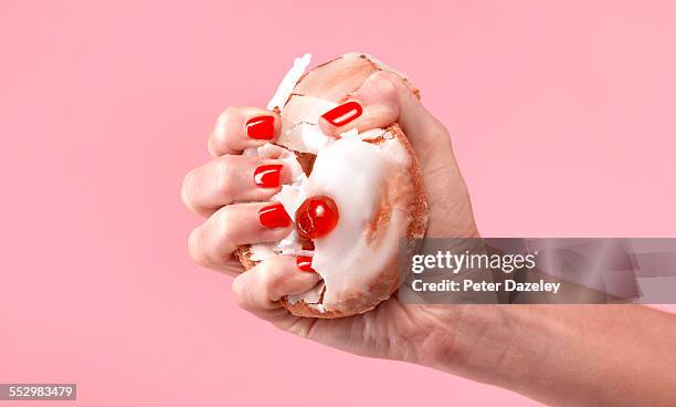 female dieter crushing belgian bun - unhealthy eating ストックフォトと画像