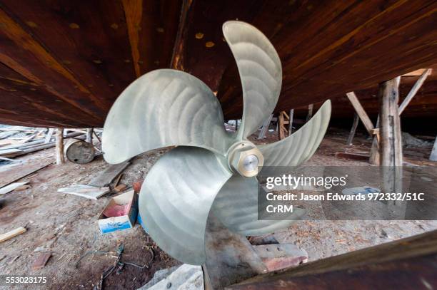 the handmade construction of an ancient timber dhow in a shipyard and a stainless steel propeller. - akter bildbanksfoton och bilder
