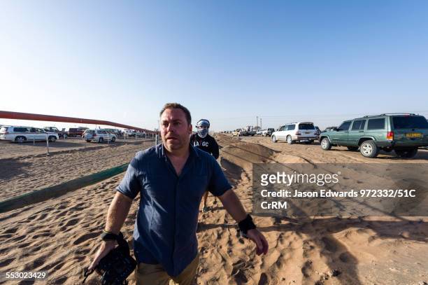 national geographic photographer jason edwards photographing at a camel race in the desert. - national geographic society stock pictures, royalty-free photos & images
