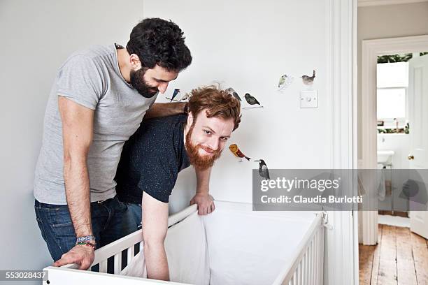 gay couple admiring their baby - modern baby nursery stock pictures, royalty-free photos & images