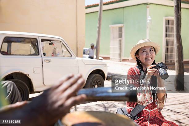 happy asian tourist with her camera in the street. - cuba car stock pictures, royalty-free photos & images