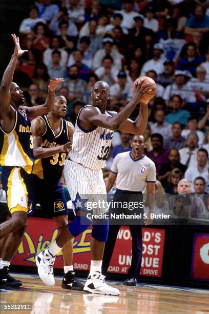 Shaquille O'Neal of the Orlando Magic keeps the ball away from two Indiana Pacers defenders during Game one in the first Round of the 1994 NBA...