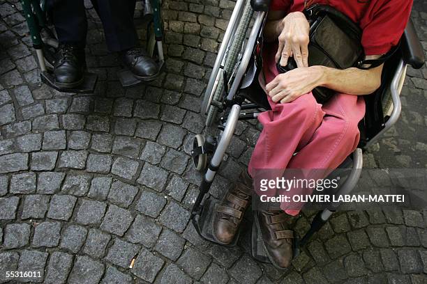 Photo d'une personne handicapee assise dans son fauteuil manuel, prise, le 08 septembre 2005 a Paris devant le ministere de la Sante, ou quelques...