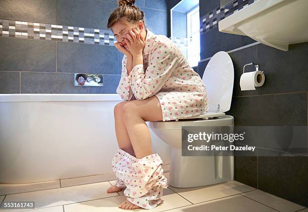 teenager in pain on the toilet - diarrhoea foto e immagini stock