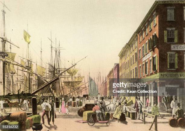 Colorized engraving shows a view down South Street from it's intersection with Maiden Lane, New York, New York, 1828. Visible are men and women...