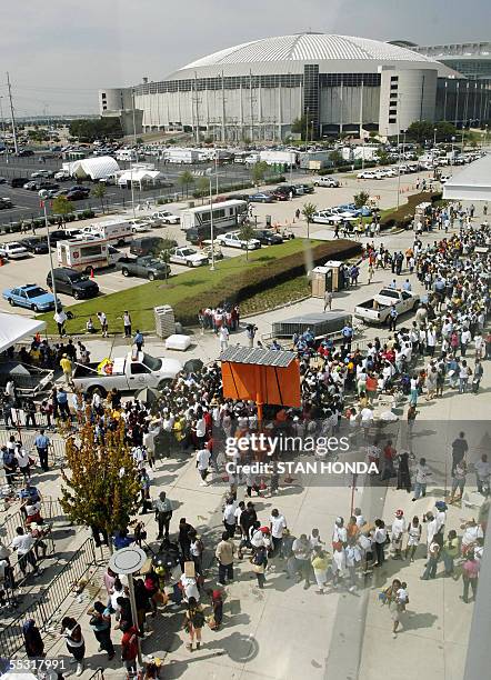 Houston, UNITED STATES: A crowd of Hurricane Katrina evacuees line up to receive a debit card from the Red Cross, 08 September outside the Reliant...