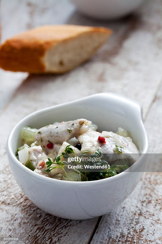 Bowl of pickled herring salad with cress