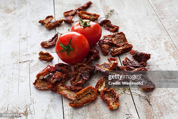 dried and fresh tomatoes on wood - sonnengetrocknete tomate stock-fotos und bilder