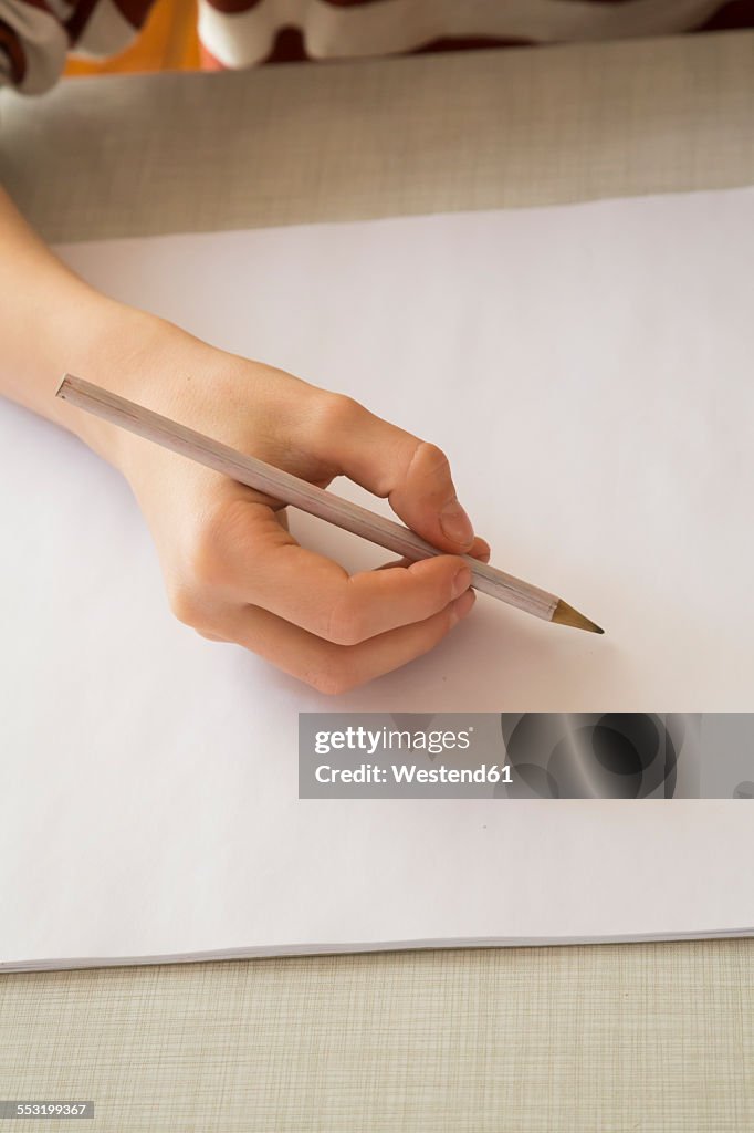 Boy's hand holding pencil