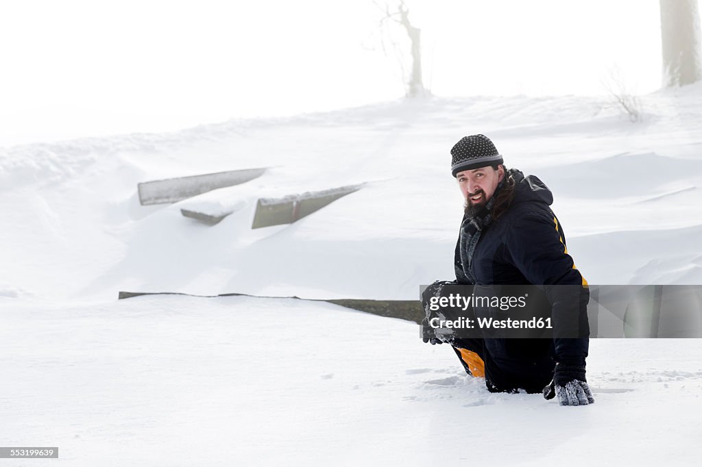 Germany, Baden-Wuerttemberg, Waldshut-Tiengen, man sinking in deep snow