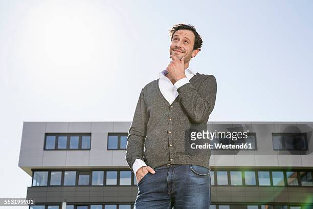 smiling businessman with hand on chin looking up - man looking up beard chin imagens e fotografias de stock