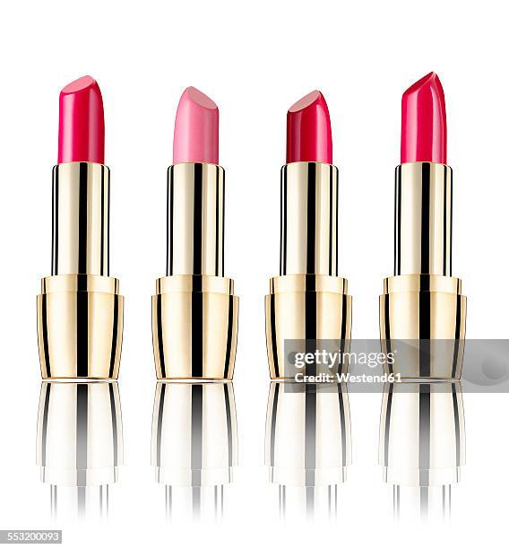 row of four lipsticks in front of white background - lipstick fotografías e imágenes de stock