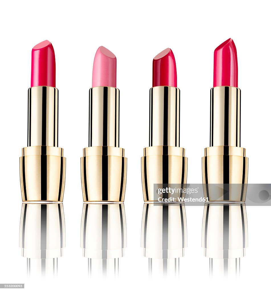 Row of four lipsticks in front of white background