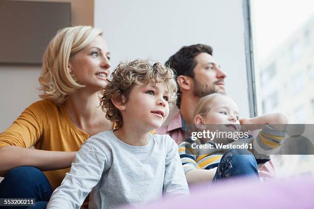 family looking out of window - gezin met twee kinderen stockfoto's en -beelden