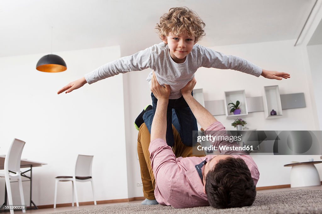 Father playing with son at home