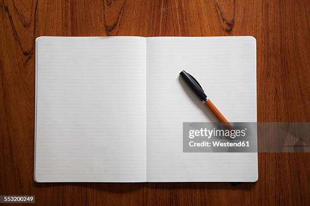 ballpen lying on opened notebook - pen and note pad stock pictures, royalty-free photos & images