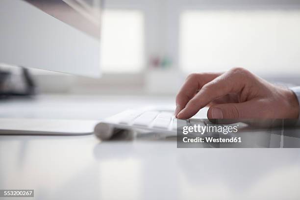 man's hand typing on keyboard of computer - computertastatur stock-fotos und bilder