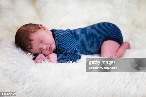 baby boy sleeping on sheepskin - sheepskin stock pictures, royalty-free photos & images