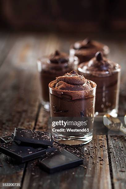 glasses of vegan mousse au chocolat and bittersweet chocolate on wood - chocolade mousse stockfoto's en -beelden