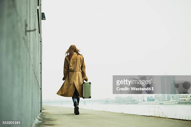 young woman with suitcase walking by the riverside - 18 19 anni foto e immagini stock