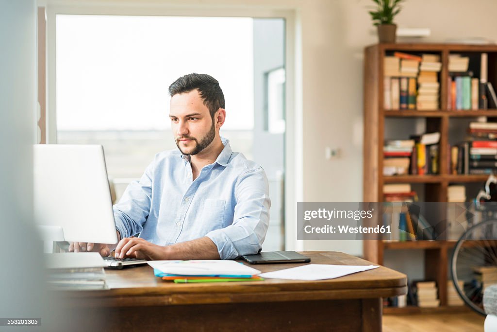 Young man working at computer at home