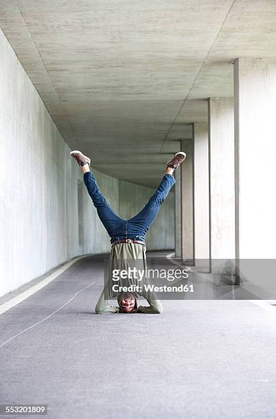 young man doing headstand in an underpass - headstand ストックフォトと画像