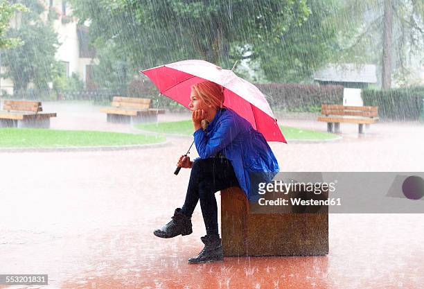austria, thalgau, teenage girl with red umbrella sitting on her suitcase in the rain - one teenage girl only bildbanksfoton och bilder