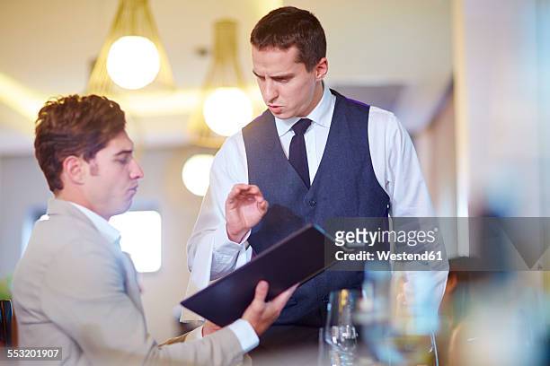 businessman placing an order with waiter at hotel restaurant - meal expense stock pictures, royalty-free photos & images
