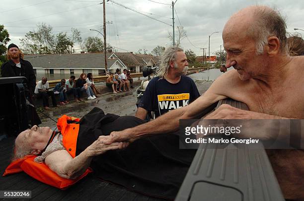 Unidentified people just rescued from the Lower Ninth Ward recuperate on the St. Cloud bridge in New Orleans, Louisiana on August 29, 2005. Hurricane...