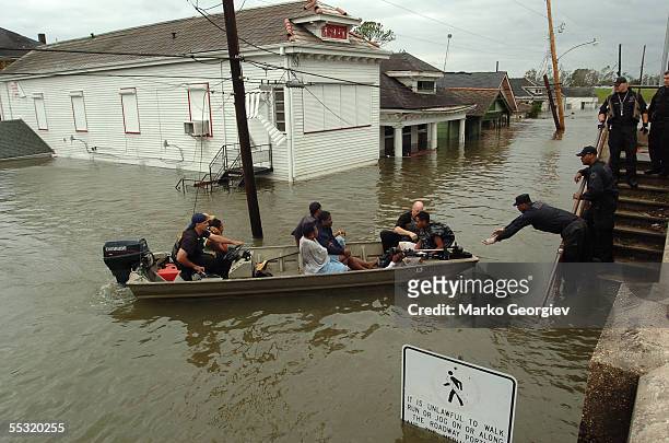 New Orleans police bring people ashore from the rescue boats at the flooded Lower Ninth Ward in New Orleans, Louisiana on August 29, 2005. Hurricane...